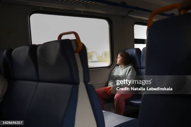 overweight teenage girl on train with smartphone looking at window. - plump girls stockfoto's en -beelden