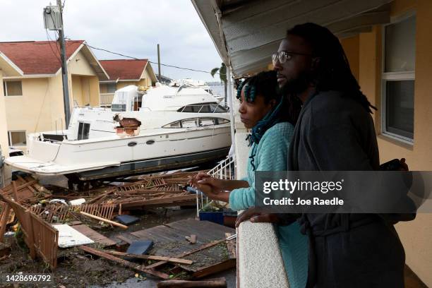 Frankie Romulus and Kendrick Romulus stand outside of their apartment next to a boat that floated into their apartment complex when Hurricane Ian...