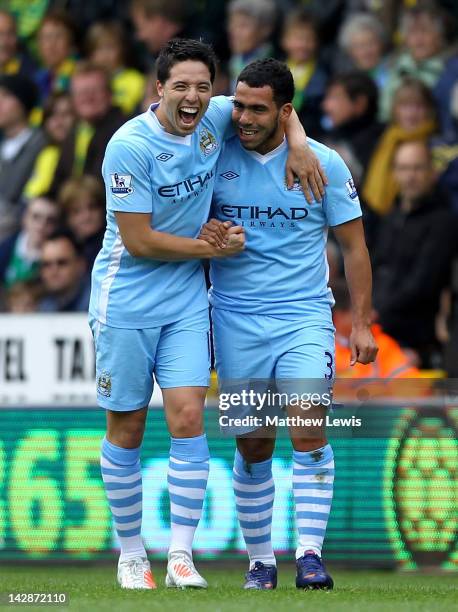 Carlos Tevez of Manchester City celebrates scoring the opening goal with team mate Samir Nasri during the Barclays Premier League match between...