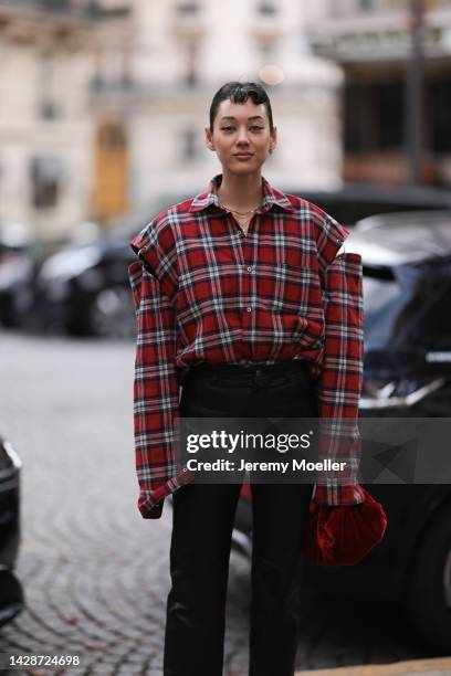 Kim Jones is seen wearing red checked oversized button shirt, black shiny leather pants and a red velvet bag, outside Undercover, during Paris...