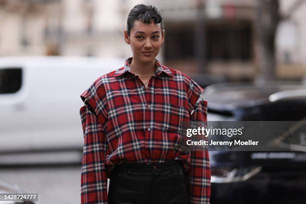 Kim Jones is seen wearing red checked oversized button shirt, gold necklaces and black shiny leather pants, outside Undercover, during Paris Fashion...