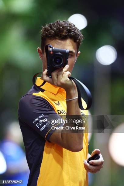 Lando Norris of Great Britain and McLaren holds a camera in the Paddock during previews ahead of the F1 Grand Prix of Singapore at Marina Bay Street...