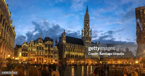 brussels town hall at grand place illuminated at dusk - belgische cultuur stockfoto's en -beelden