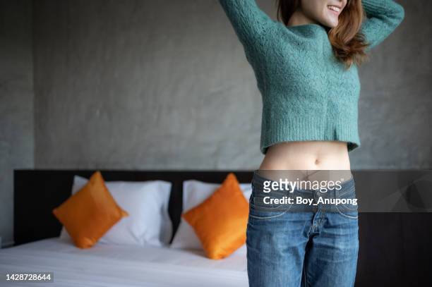 cropped shot of slim woman while wearing jeans. - slank stockfoto's en -beelden