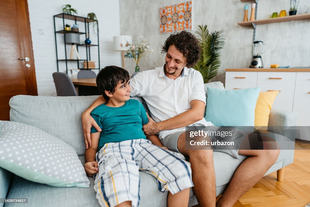 Father Talking With His Son On The Sofa