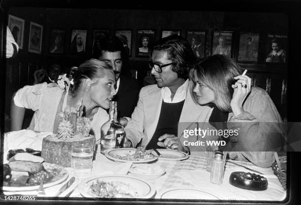 Margaux Hemingway, guest, Robert Evans, and Lisa Taylor attend a BBQ-themed party at Gallagher's in New York City on May 12, 1975.