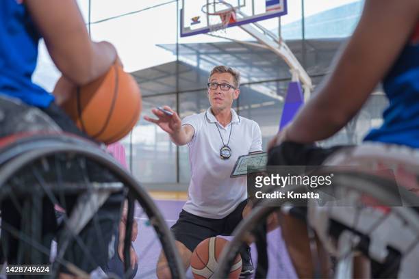 wheelchair basketball players meeting with coach. - wheelchair basketball team stock pictures, royalty-free photos & images