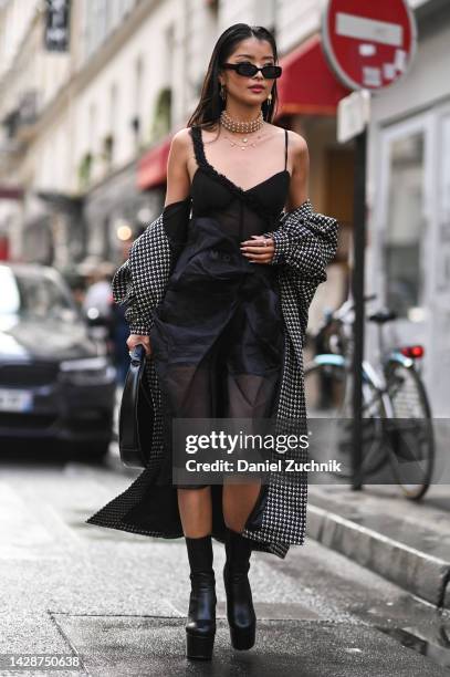 Caroline Hu is seen wearing a Bolder Paris coat, black sheer outfit, black shorts and black boots with black sunglasses and a black bag outside the...