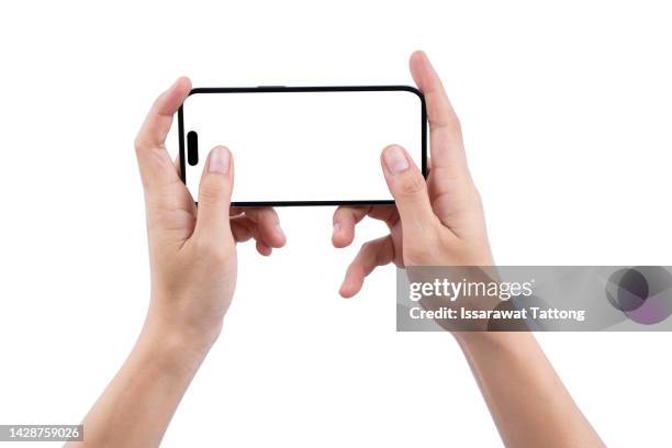 female's hands playing on smartphone isolated on white background. hands of woman holds a black smartphone and play a game. horizontal position. screen blank. close-up. - querformate stock-fotos und bilder