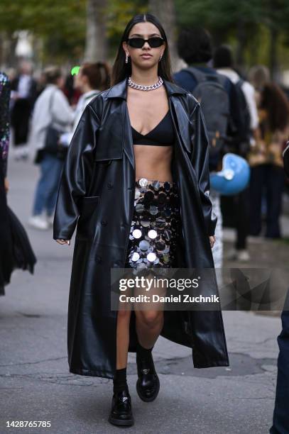 Guest is seen wearing a black leather coat, black bralette, reflective skirt and black Prada shoes outside the Acne show during Paris Fashion Week...