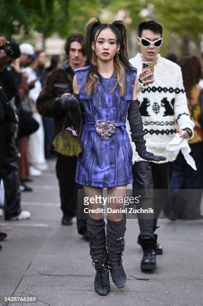 Guest is seen wearing a black and purple Acne dress and Acne bag with knit sleeves and knit Acne boots outside the Acne show during Paris Fashion...