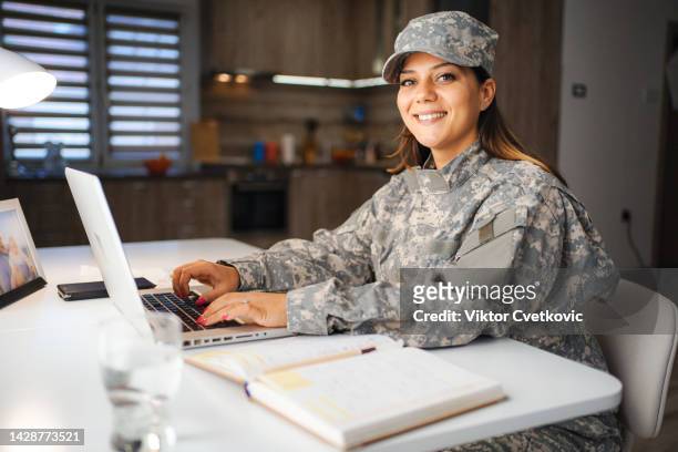 portrait of a female soldier working on laptop at home - veteran entrepreneur stock pictures, royalty-free photos & images