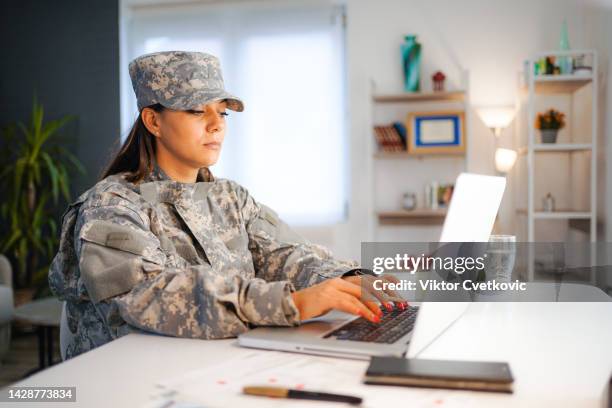 female soldier working on laptop at home - veteran entrepreneur stock pictures, royalty-free photos & images