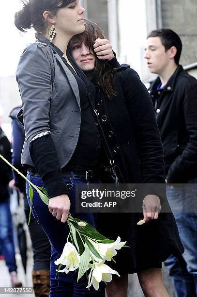 People take part in a silent march on April 14, 2012 in the streets of Nantes, western France, to mark the first anniversary of the murders of the...