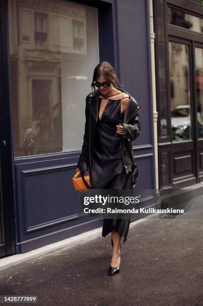 Darja Barannik wearing a black leather dress, a black leather jacket, and an orange bag outside Rochas, during Paris Fashion Week - Womenswear...