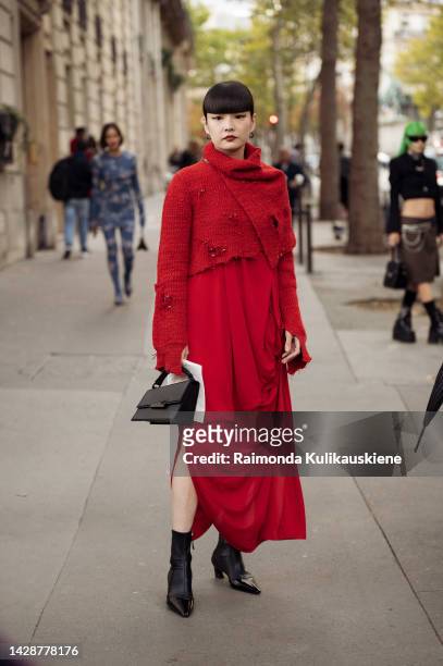 Kozue Akimoto wearing a red wool turtleneck ripped pullover, a red long maxi dress with pleats, a black Acne bag, black pointed high heel ankle...