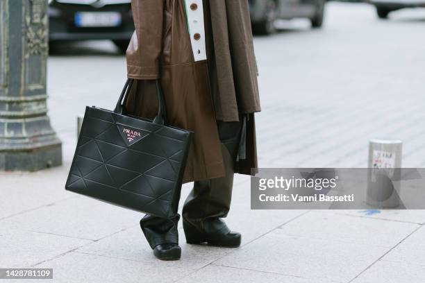 Guest poses wearing a Victoria Tomas brown coat and a Prada leather tote bag after the Schiaparelli show in Place Vendome during Paris Fashion Week -...