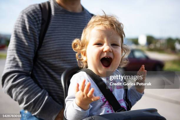 babymädchen auf fahrradsitzroute mit ihrem vater - fahrradsattel stock-fotos und bilder