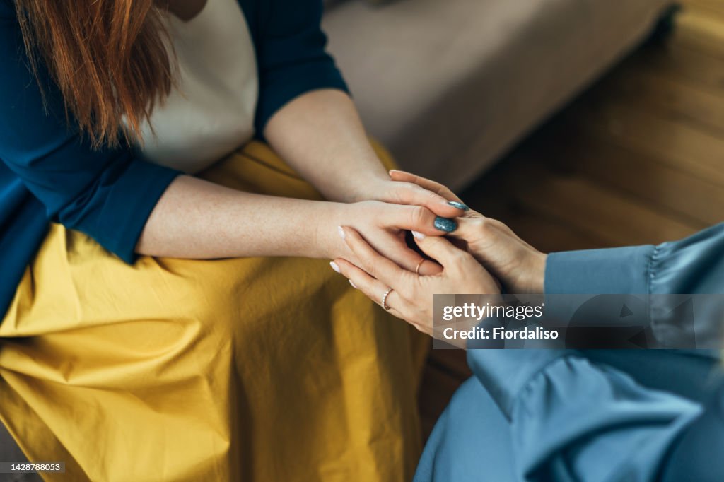 Two women sitting in armchairs and talking. Woman psychologist talking to patient