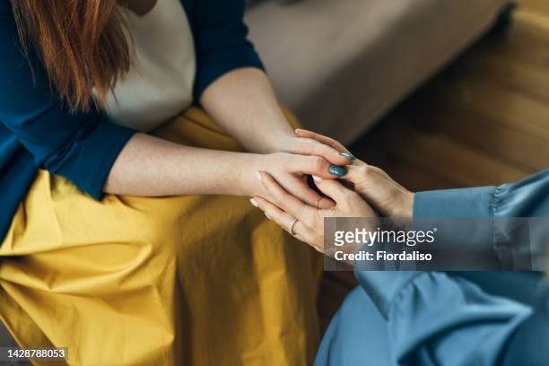 two women sitting in armchairs and talking. woman psychologist talking to patient - helping hand stock-fotos und bilder