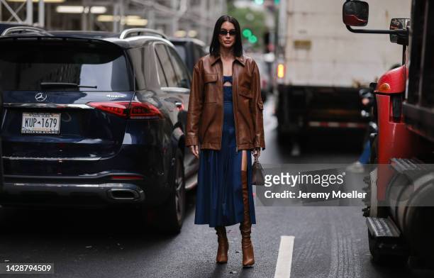 Brittany Xavier seen wearing a blue dress with a brown leather jacket and brown overknee boots, outside Carolina Herrera during new york fashion week...