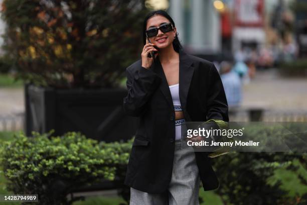 Fashion week guest seen wearing a black and grey suit, outside Carolina Herrera during new york fashion week on September 12, 2022 in New York City.