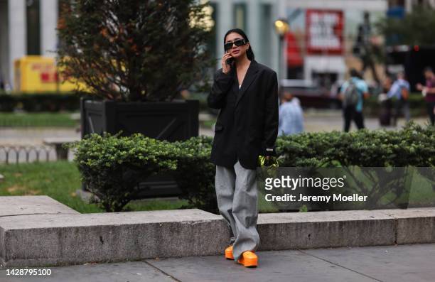 Fashion week guest seen wearing a black and grey suit, outside Carolina Herrera during new york fashion week on September 12, 2022 in New York City.