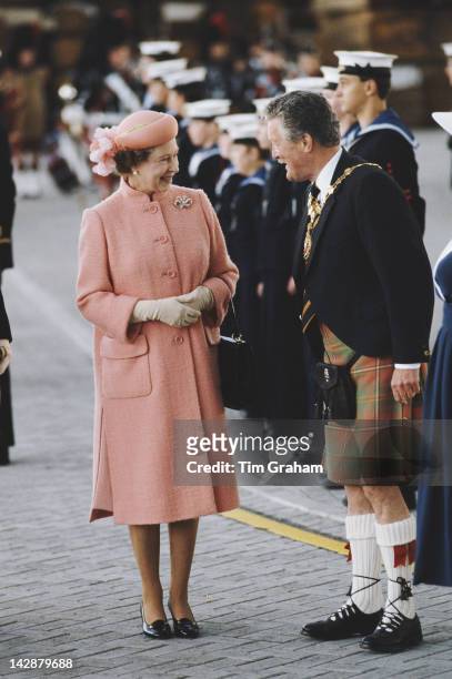 Queen Elizabeth II meets a group of Royal Navy sailors in Inverness, Scotland, 15th August 1985. She is wearing a hat by milliner Frederick Fox. She...