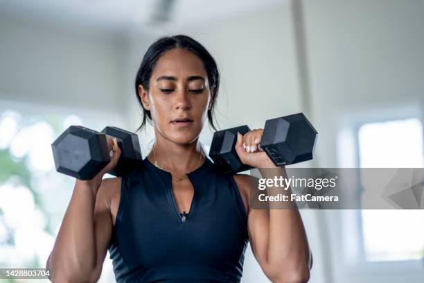 mujer levantamiento de peso - entrenamiento de fuerza fotografías e imágenes de stock