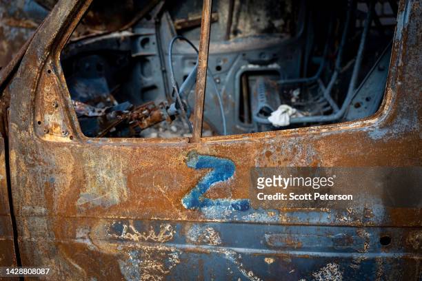 Destroyed and rusting car is marked with the Russian military symbol Z, at the ruins of a Russian military field hospital in Izium Middle School No....