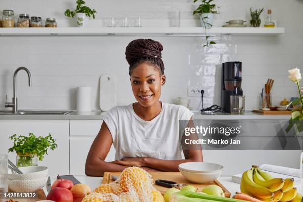 portrait of a beautiful young black woman in the kitchen, representing a healthy lifestyle - representing stock pictures, royalty-free photos & images