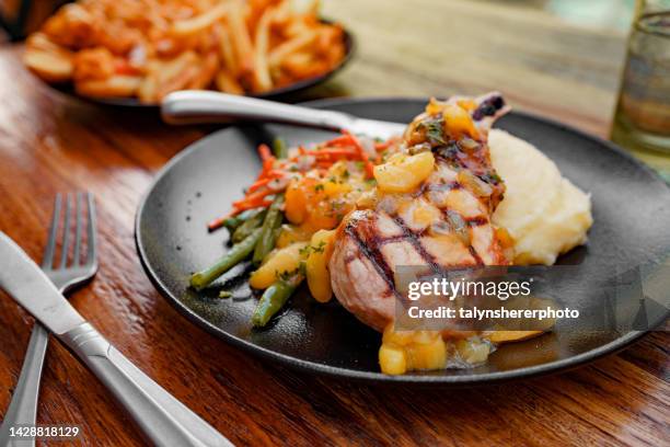 schweinekoteletts mit kartoffelpüree und gemüse - schweinekotelett stock-fotos und bilder