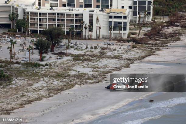 In this aerial view, a Coast Guard helicopter sits on the beach as search and rescue efforts continue after Hurricane Ian passed through the area on...