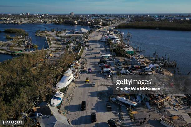 In this aerial view, boats sit grounded in a woodland area and along the side of the road after being pushed by rising water from Hurricane Ian near...