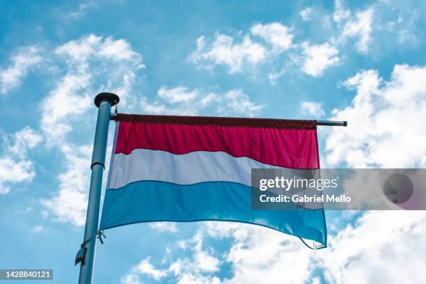 luxembourg flag against cloud sky - luxembourg benelux stock-fotos und bilder