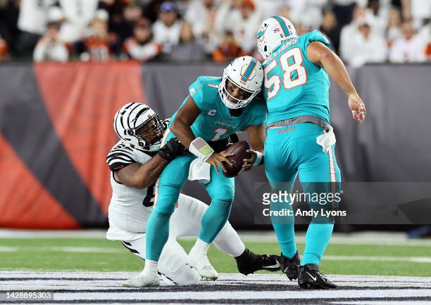 Quarterback Tua Tagovailoa of the Miami Dolphins is sacked by defensive tackle Josh Tupou of the Cincinnati Bengals during the 2nd quarter of the...