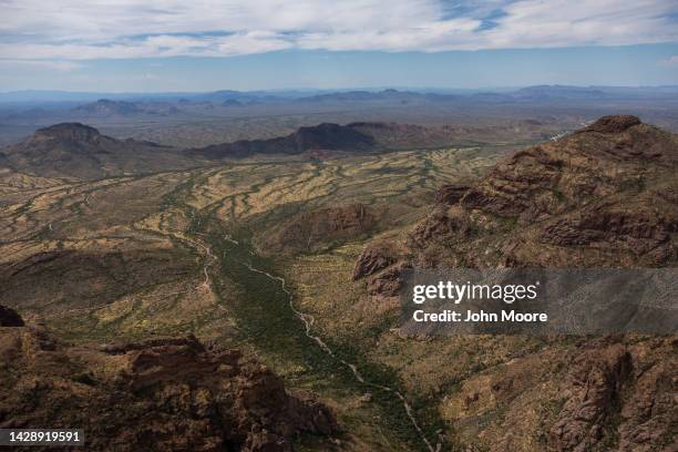 As seen from a U.S. Customs and Border Protection helicopter, rugged terrain of the Ajo Mountains towers over the Sonoran Desert on September 28,...