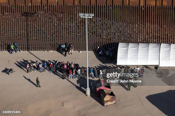 Immigrants await processing by U.S. Border Patrol agents while seeking asylum in the United States on September 28, 2022 near Yuma, Arizona. U.S....