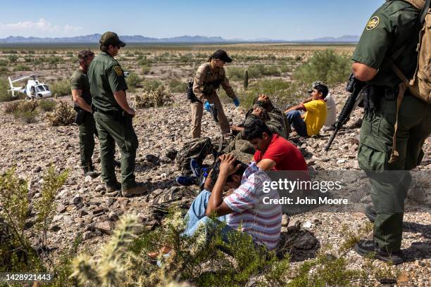 Customs and Border Protection agents detain a group of immigrants after tracking them through rugged terrain on September 28, 2022 at the Organ Pipe...