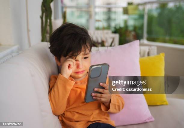 cute little boy crying because he doesn't want to give the phone back - alleen één jongen stockfoto's en -beelden