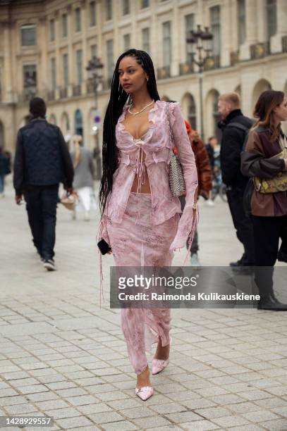 Jamilla Strand wearing a pink semitransparent long maxi skirt, long sleeve matching pink top, and pearl necklace with her name outside the Chloe show...