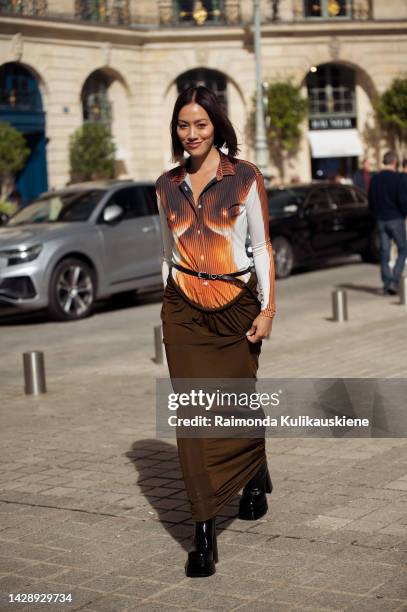 Tiffany Hsu wearing a brown, white, orange top and long brown maxi skirt outside the Chloe show during Paris Fashion Week S/S 2023 on September 29,...