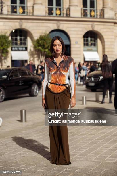 Tiffany Hsu wearing a brown, white, orange top and long brown maxi skirt outside the Chloe show during Paris Fashion Week S/S 2023 on September 29,...