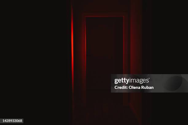 door illuminated with red lighting. - horror photos et images de collection