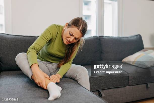 a girl suffering from pain in her leg - achilles-tendon stock pictures, royalty-free photos & images