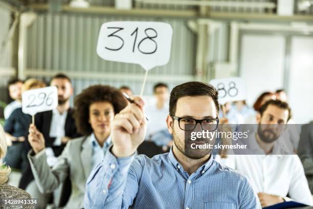 crowd of business people having an auction in a board room. - auction imagens e fotografias de stock