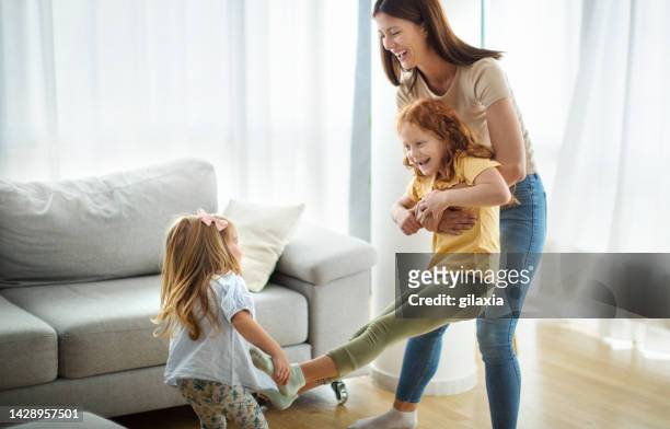 mother and daughters having fun at home. - tickling stock pictures, royalty-free photos & images