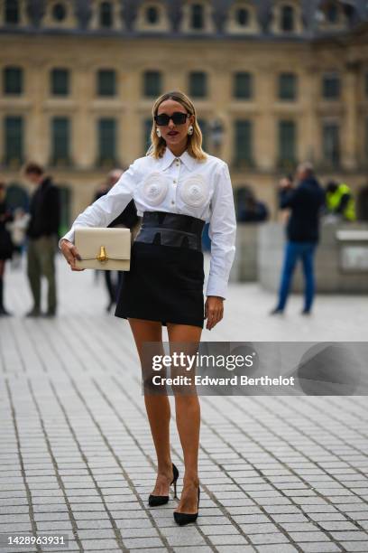 Candela Novembre wears black sunglasses from Fendi, white and gold large earrings, a white shirt with embroidered shell pattern shirt from...