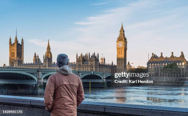 a man looks at big ben and westminster bridge in london at sunrise - london tourist stock pictures, royalty-free photos & images