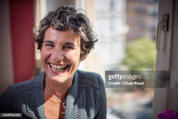 portrait of happy mature woman at the window - central europe stock pictures, royalty-free photos & images